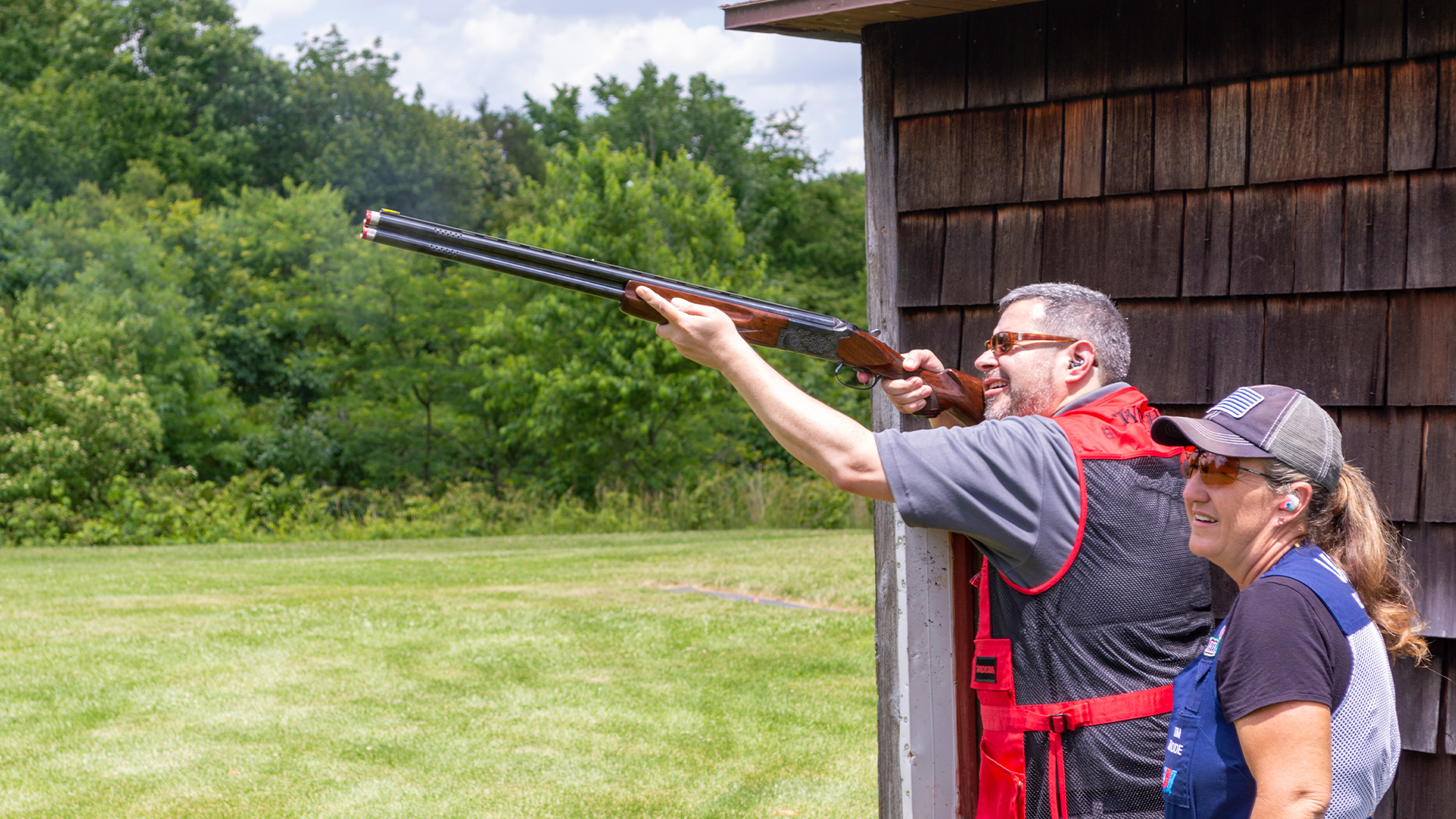 John Parker with shotgun as Kim Rhode watches him shoot